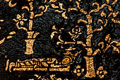 Wat Xieng Thong temple in Luang Prabang, Laos. Detail of the  intricate gold stencilling on black lacquer that decorate the walls of the sim.